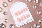 Set of pink and white nail art tips on packaging in close-up view 