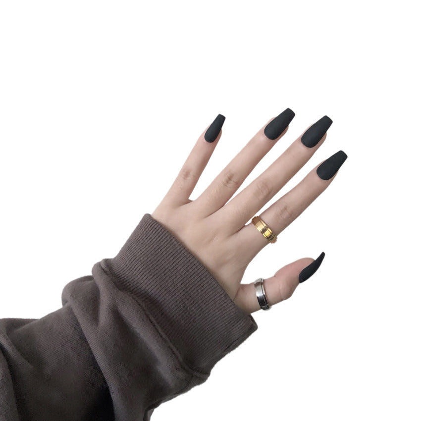 Matte black press-on nails on model finger 