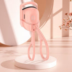 Pink handheld device on a white platform with a soft pink background