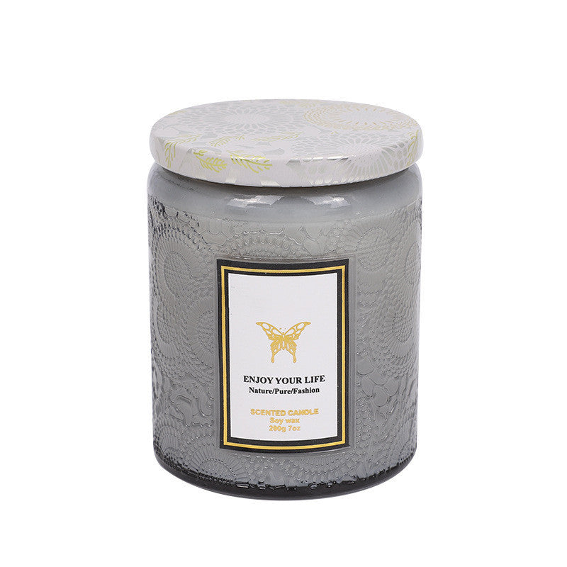 Gray textured candle jar with a white label on a white background