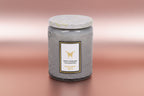 Gray textured candle jar with a white label on a white background