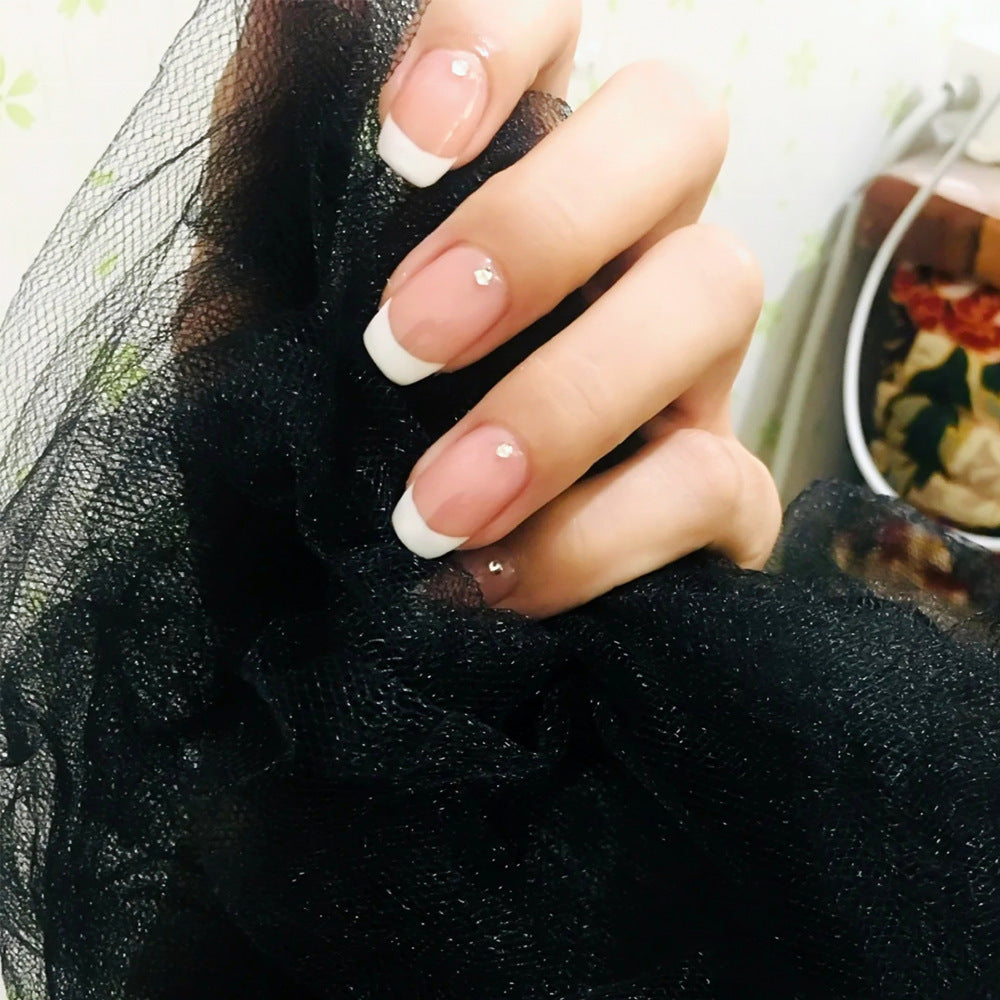 Close-up of a hand with neatly manicured nails holding a black mesh fabric.