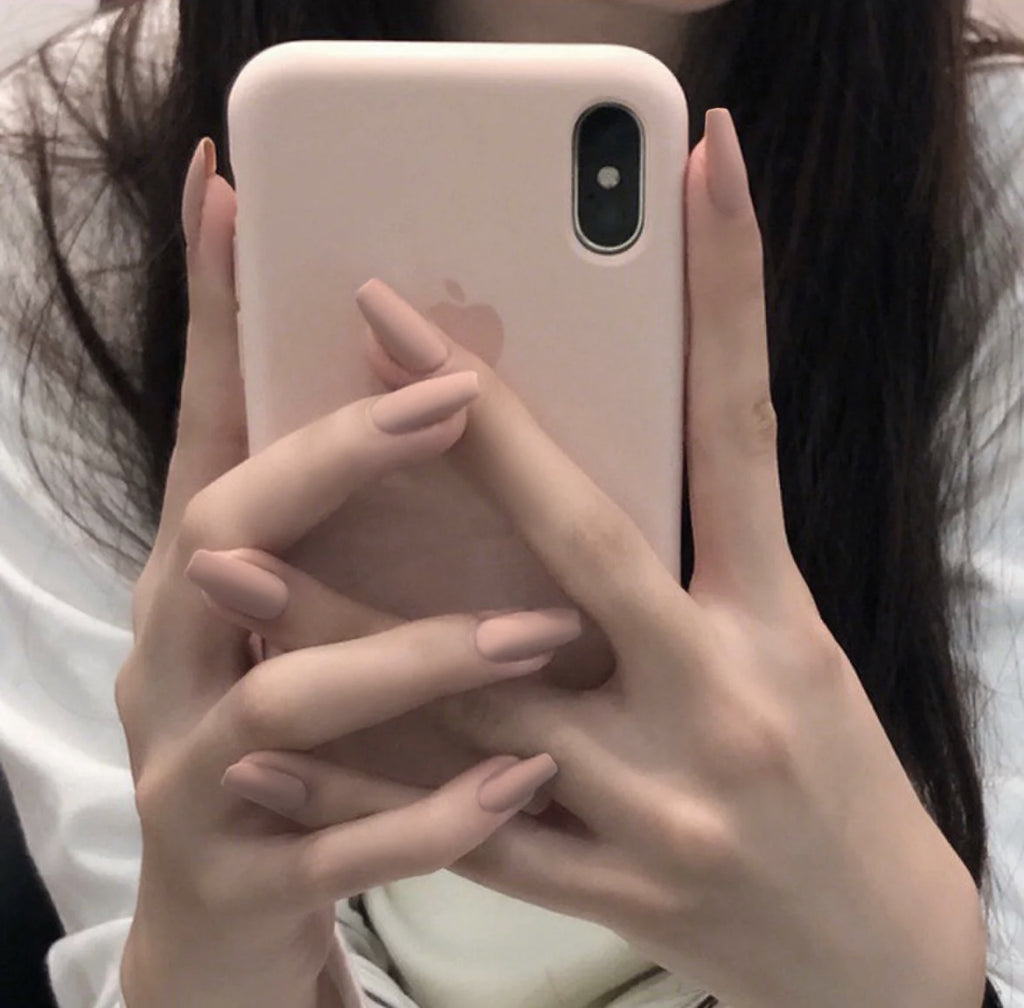 Nude colors press-on nails on model finger 