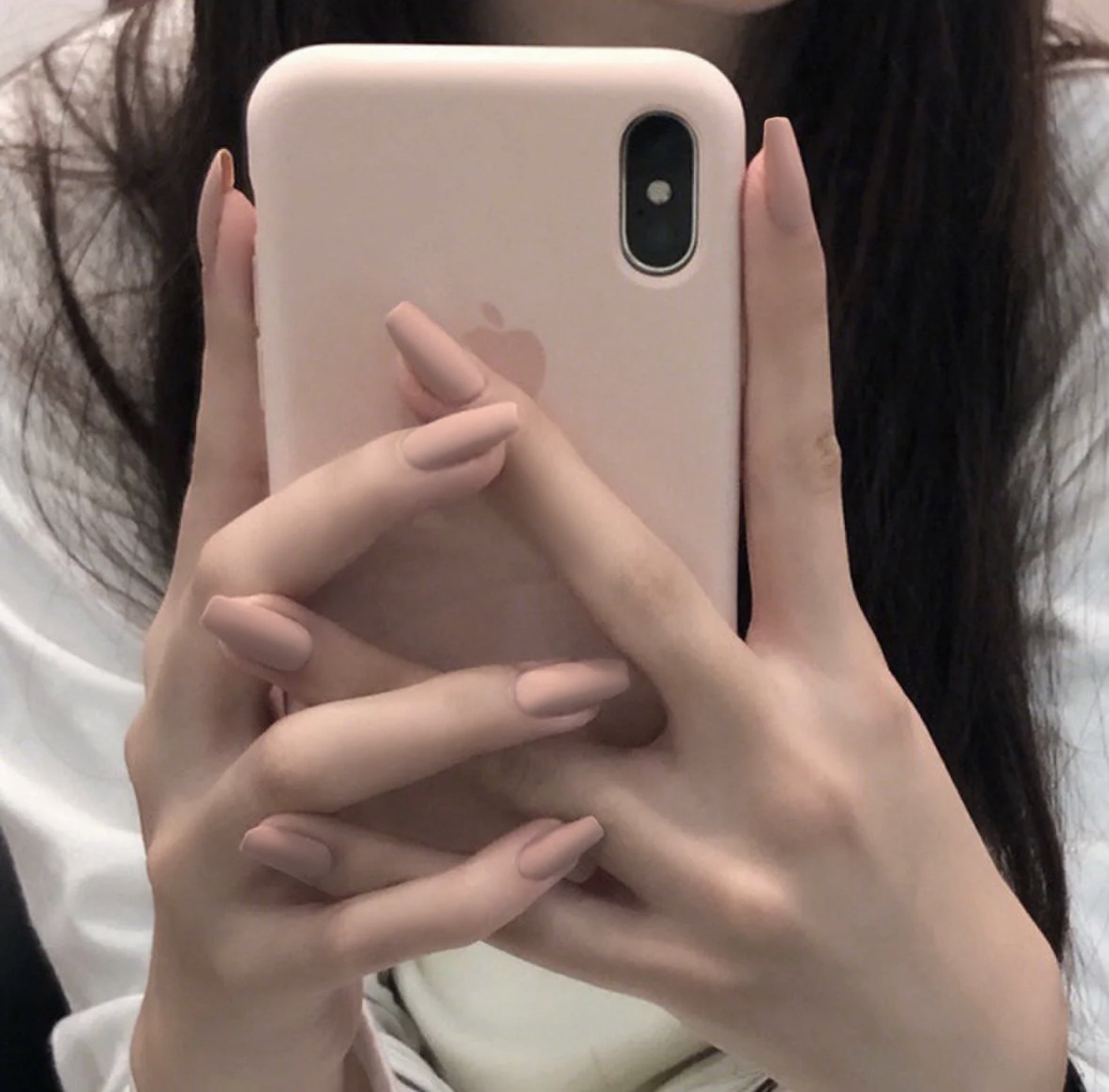 Nude colors press-on nails on model finger 