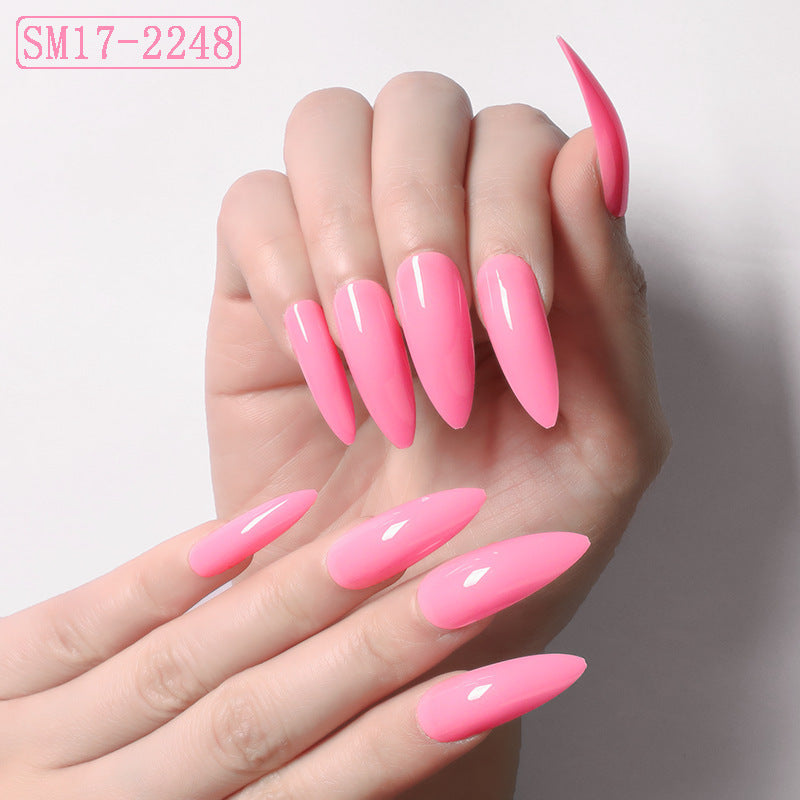Hand with pink nail polish on a plain background