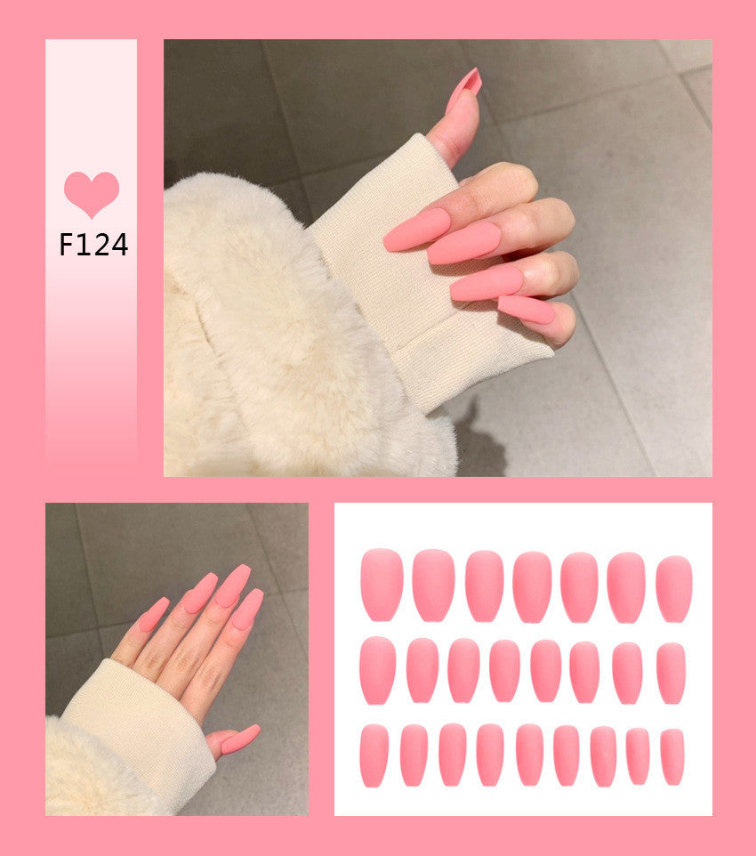 Bright pink press-on nails on model finger for salon results 