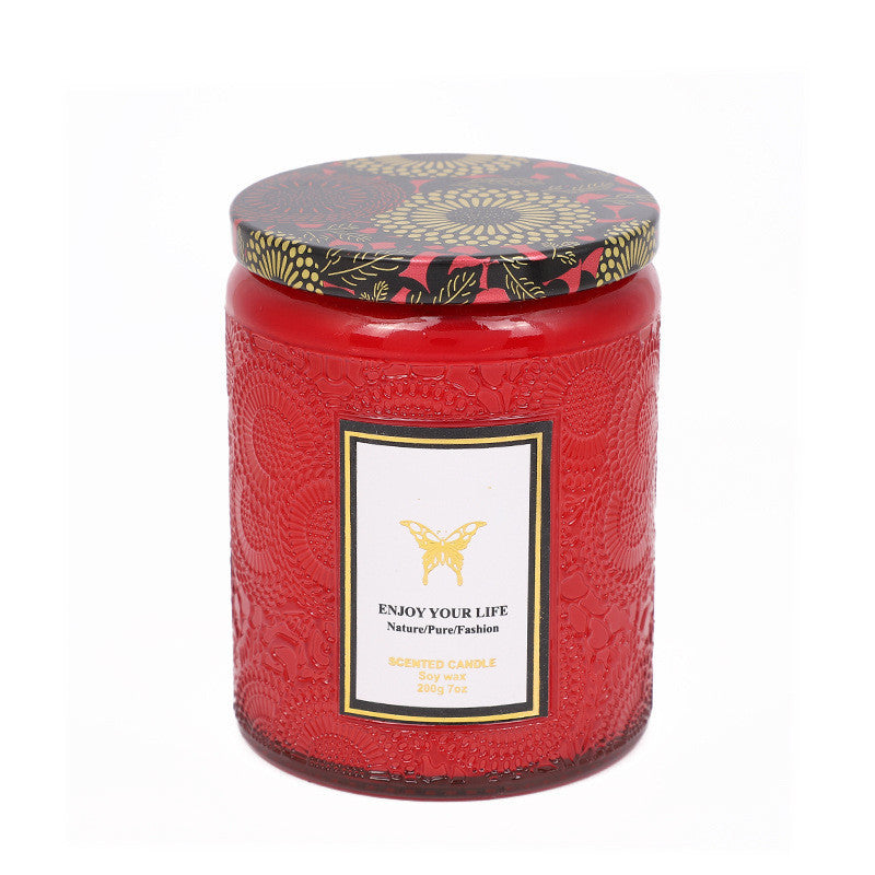 Red textured candle with decorative lid on a white background