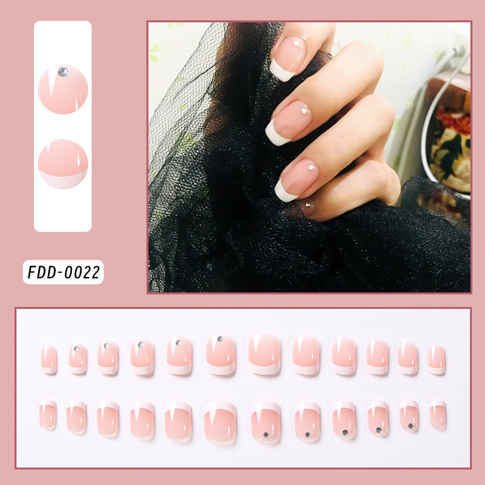 Nail art display with pink nail tips and a hand model, on white background 