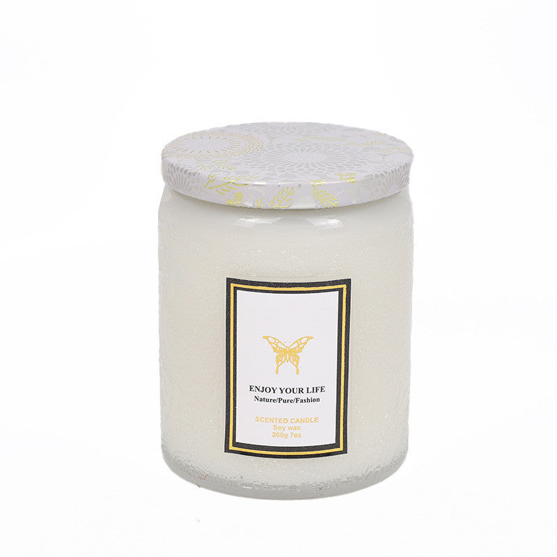 White candle with a label and decorative lid on a white background